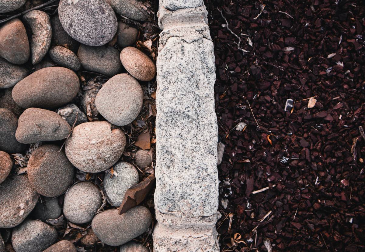 DIY homeowner installing curved decorative concrete garden edging with trowel
